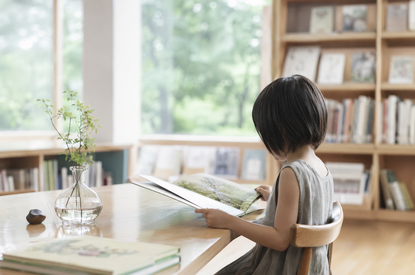 夏の図書館で涼みながら本を読む親子のイラスト